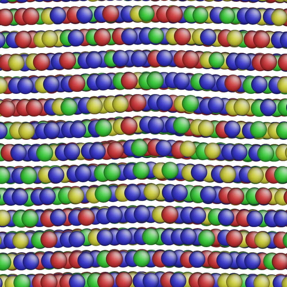 Los círculos de colores representan átomos de diferentes metales en este modelo de simulación de aleación.  Algunas filas de átomos metálicos en la estructura de la aleación se doblan debido a imperfecciones naturales en la estructura de la aleación.  La forma en que estas imperfecciones se mueven bajo tensión y tensión podría afectar la resistencia de una aleación, razón por la cual el equipo de investigación colaborativo las está visualizando tanto con microscopía como con simulaciones para entrenar su modelo de aprendizaje automático sobre cómo predecir la resistencia de la aleación.
